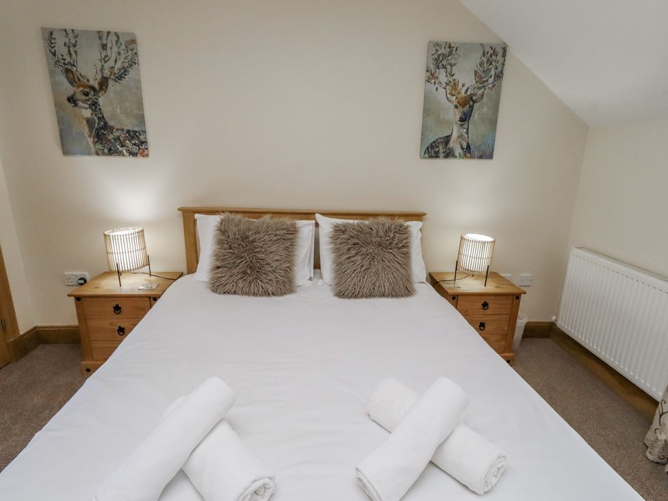 A bedroom with a bed and side tables at Low Croft in Embleton