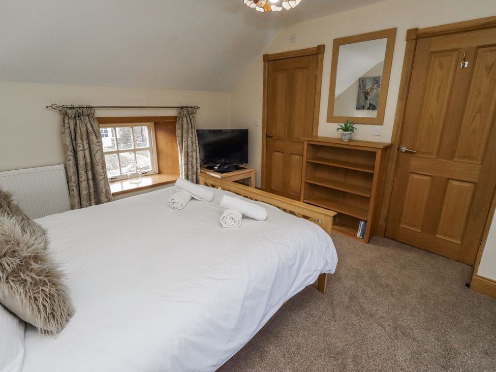 A bedroom with a bed and television at Low Croft in Embleton