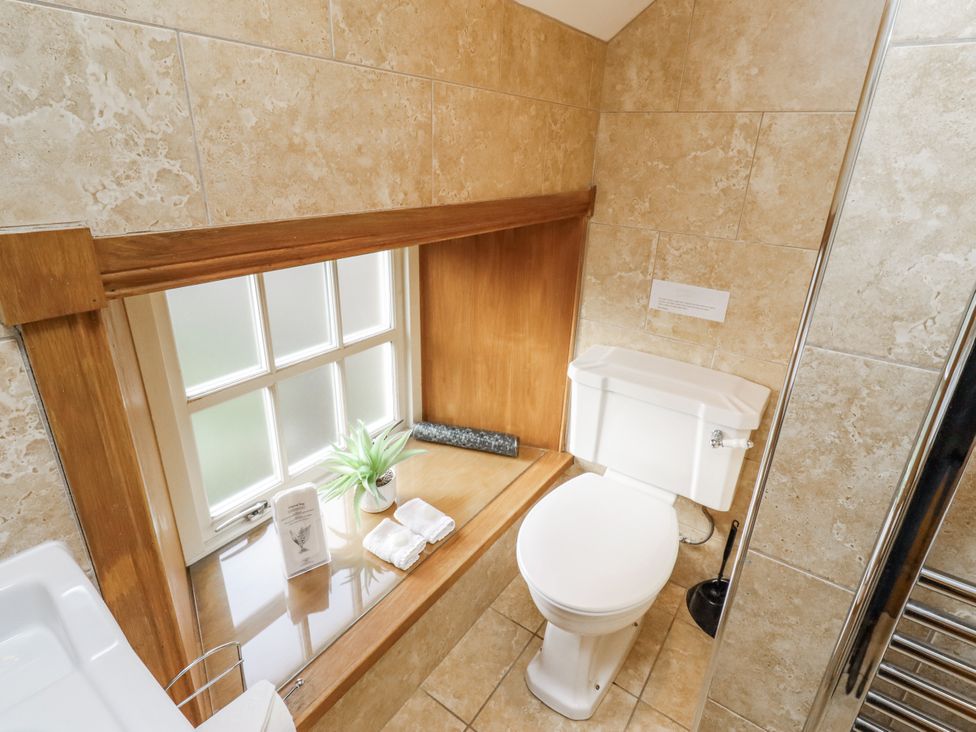 A bathroom with a toilet and window at Low Croft in Embleton