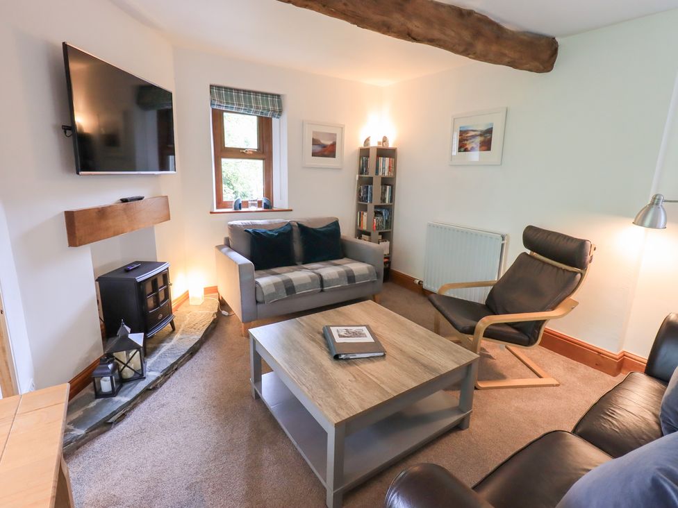 A living room with a sofa a chair and a television at Drystones in Grasmere
