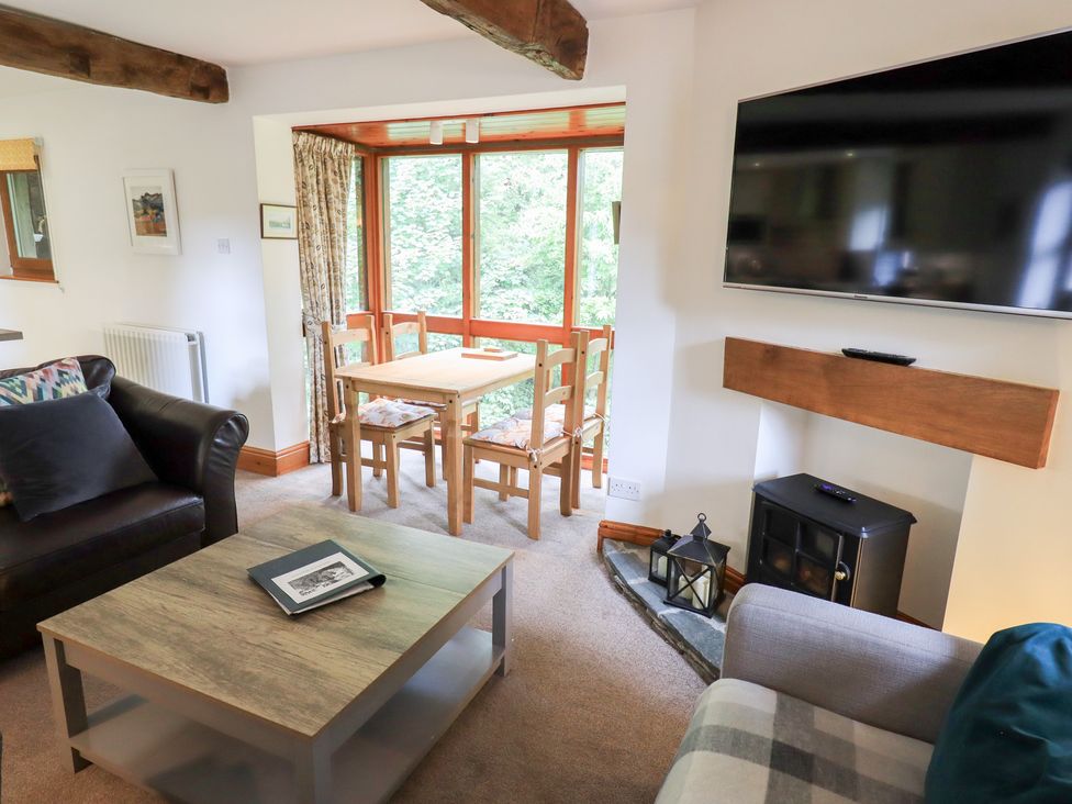 A living room with a coffee table and a dining area at Drystones in Grasmere