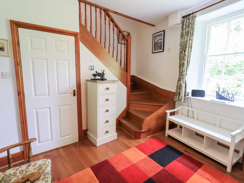 A hallway with a staircase and a chest of drawers at Drystones in Grasmere
