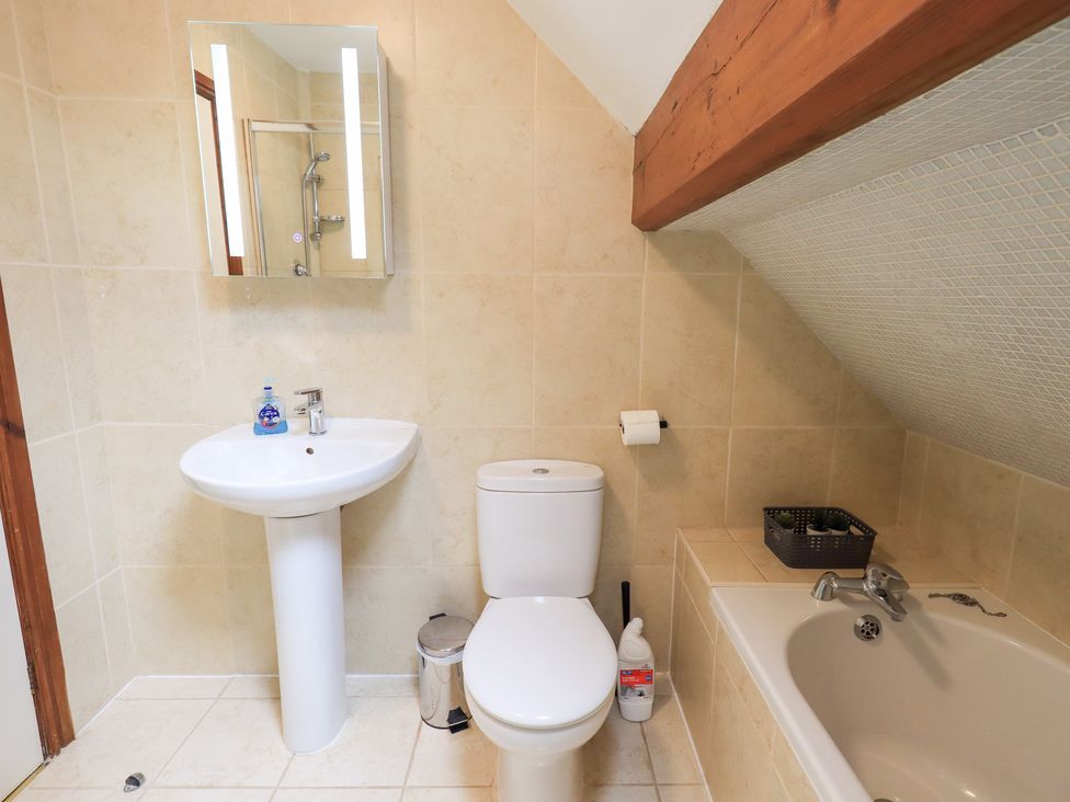 A bathroom with a sink, toilet, and bath tub at Drystones in Grasmere