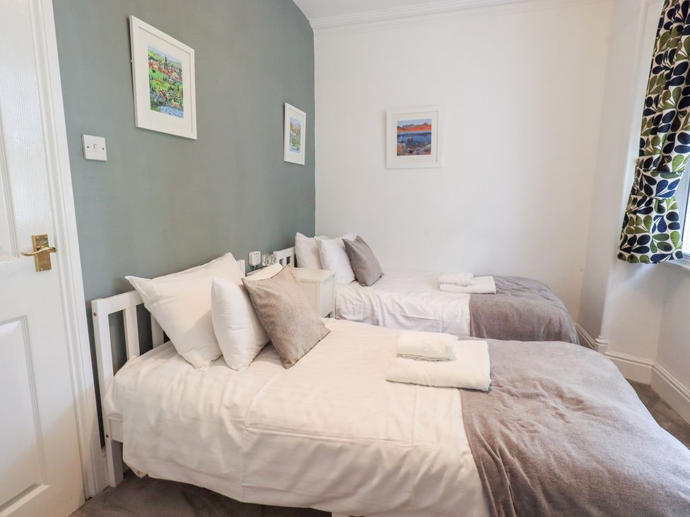 A bedroom with two beds and wall art at Drystones in Grasmere