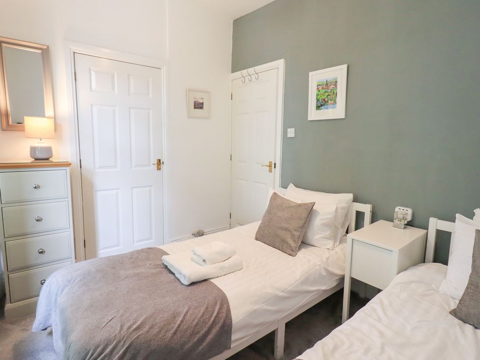 A bedroom with two single beds and a dresser at Drystones in Grasmere