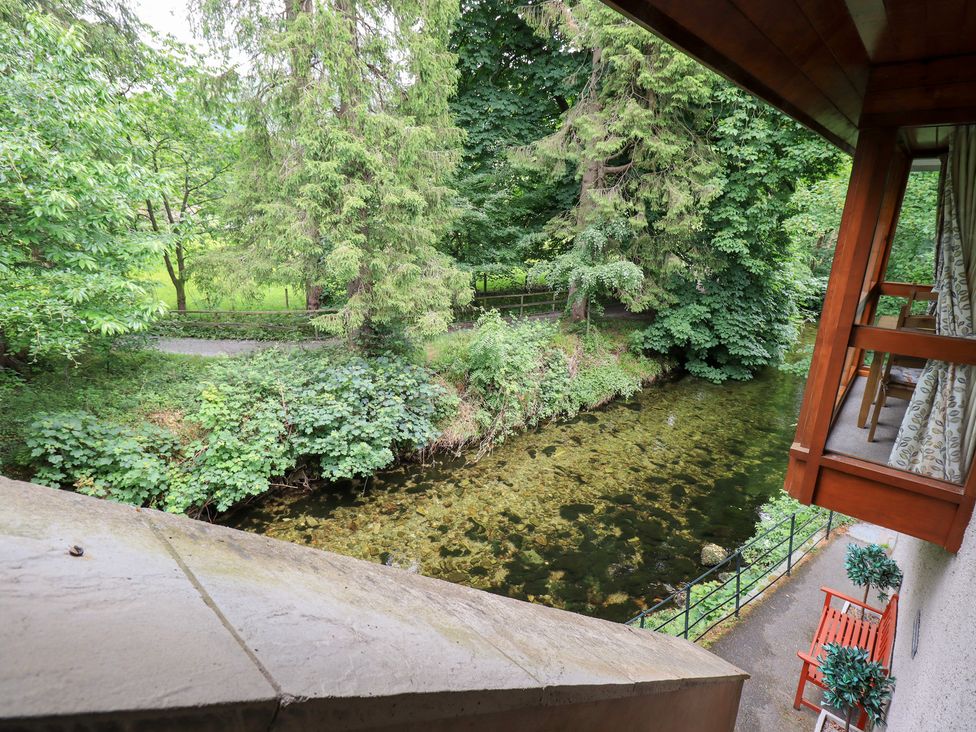 A view of a river and trees from a balcony at Drystones in Grasmere
