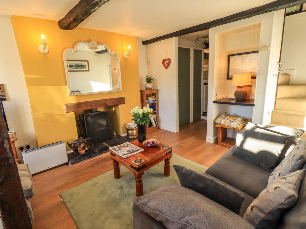 A living room with a fireplace and coffee table at Buttonhole Cottage in Ambleside