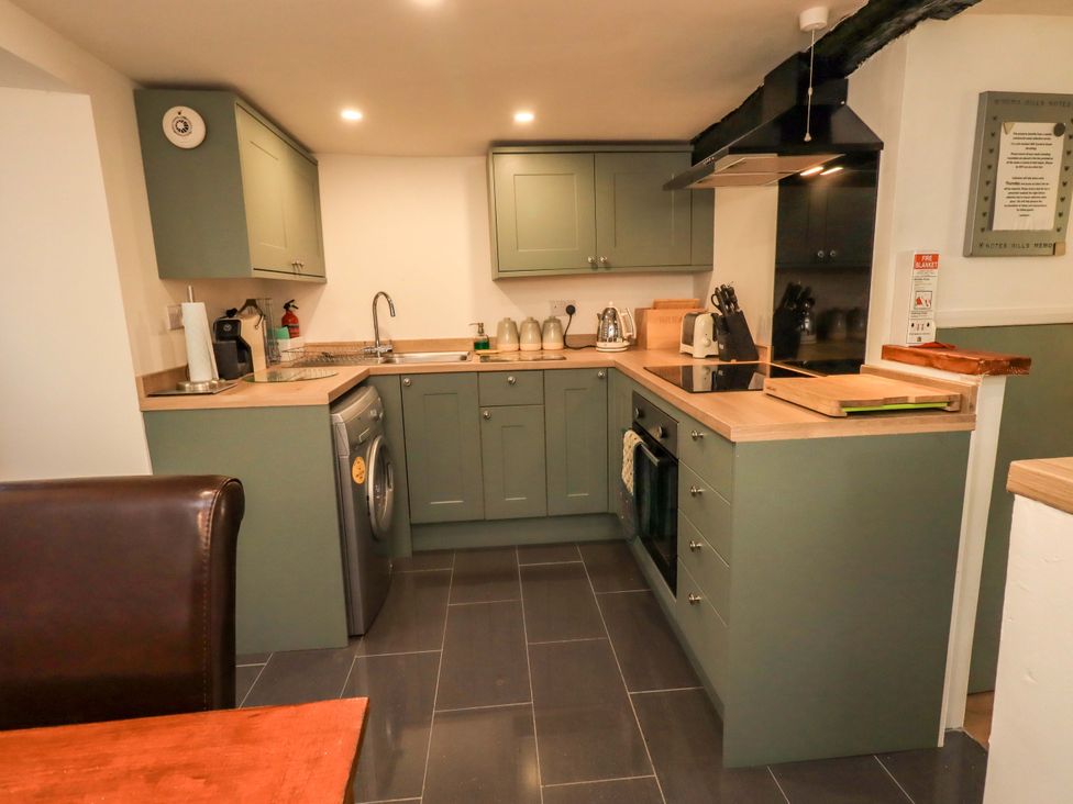 A kitchen with cabinets and appliances at Buttonhole Cottage in Ambleside