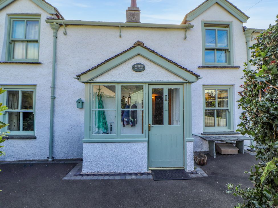 A cottage entrance with a door and windows at Sunbeam Cottage in Coniston