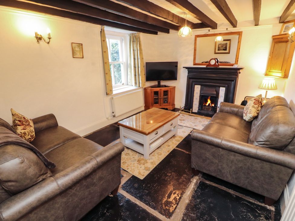 A living room with sofas and a fireplace at Sunbeam Cottage in Coniston