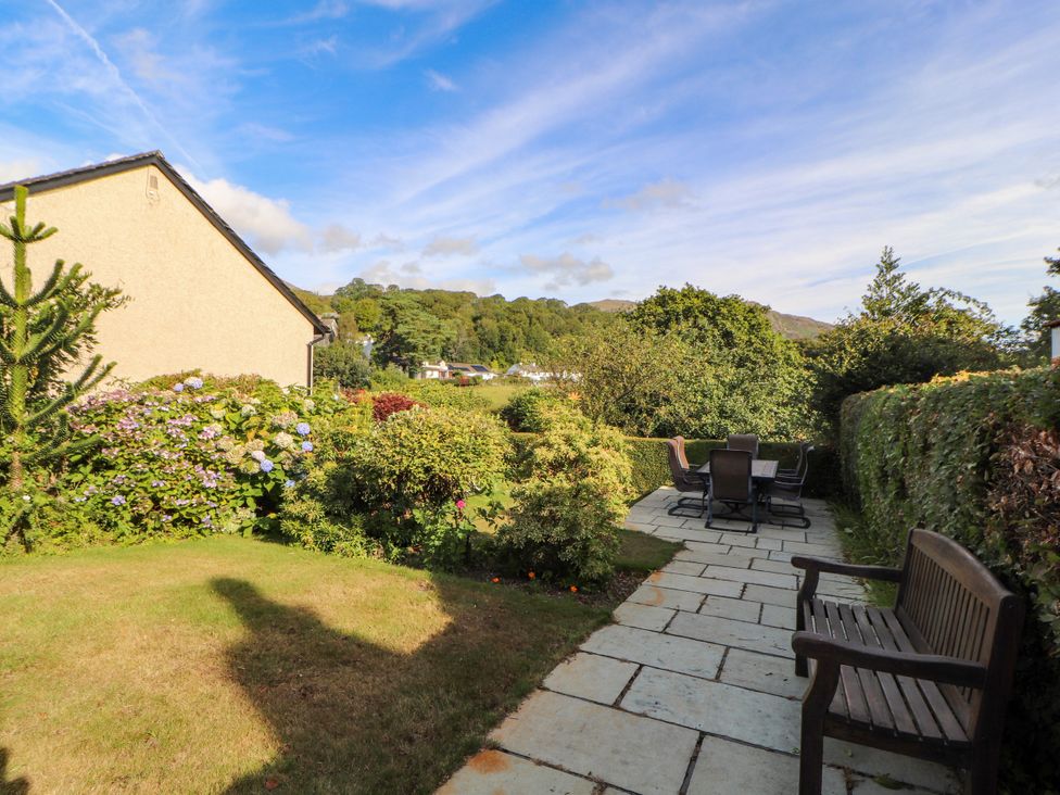 A garden with a patio and seating area at Sunbeam Cottage in Coniston