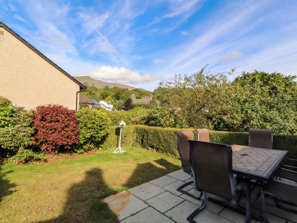 A garden with a table and chairs at Sunbeam Cottage in Coniston