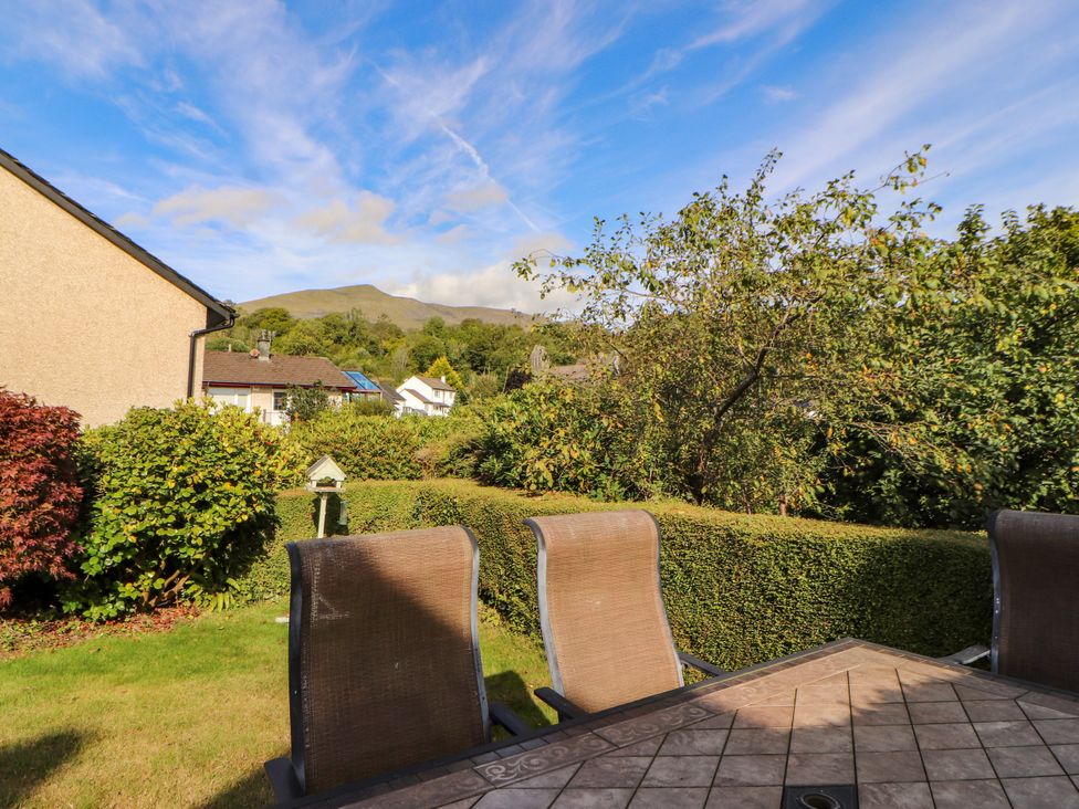 A garden with a table and chairs surrounding it at Sunbeam Cottage in Coniston