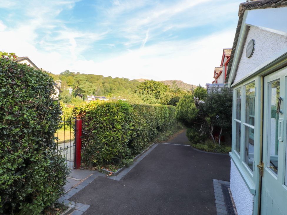 A pathway lined with hedges and leading to a house at Sunbeam Cottage in Coniston