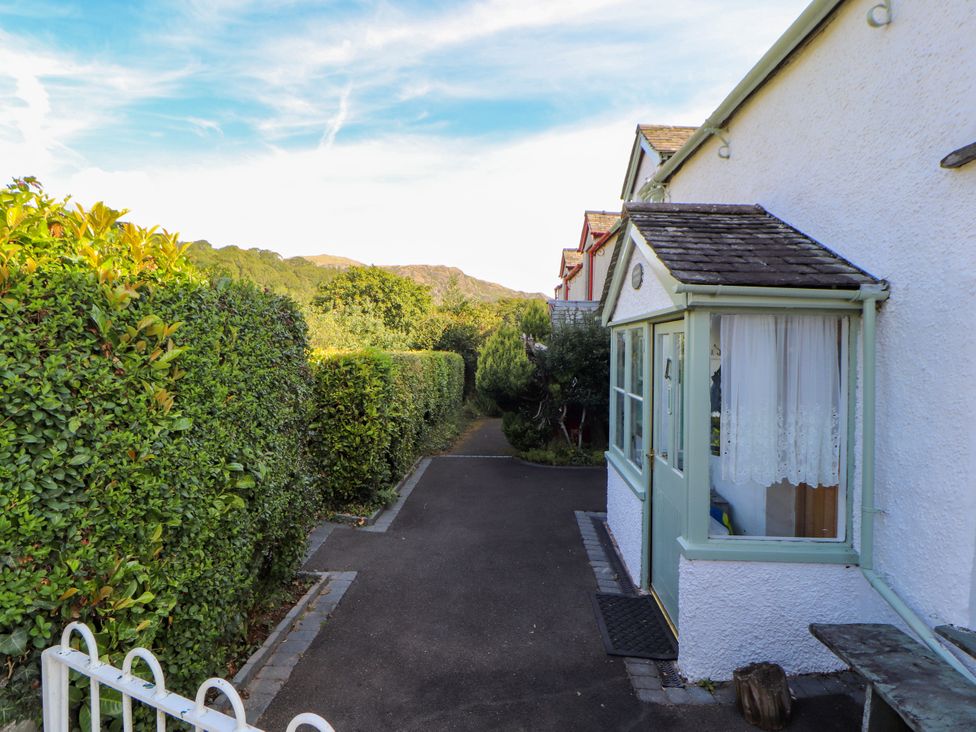 A pathway bordered by hedges with a house at Sunbeam Cottage in Coniston