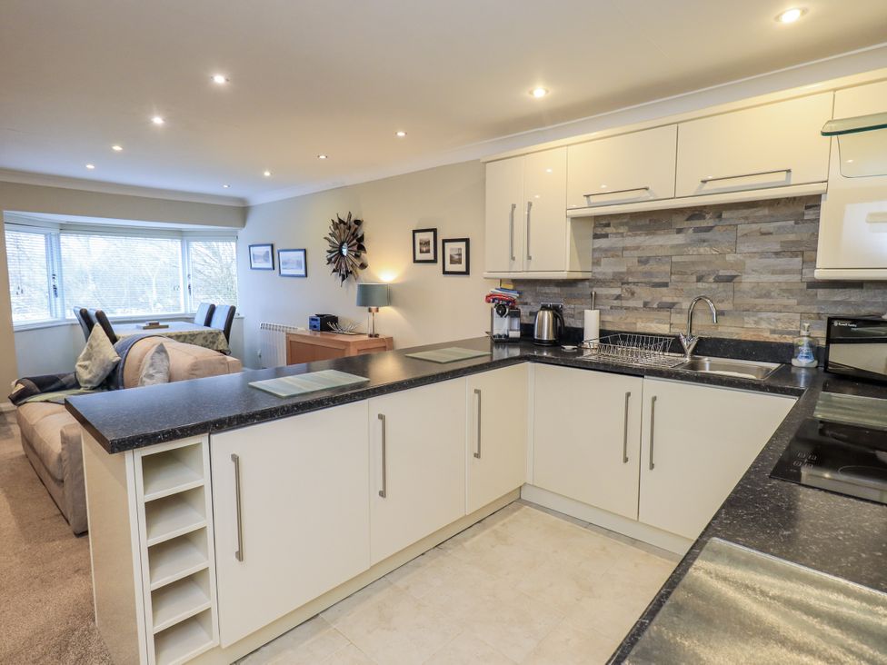 A kitchen with appliances and a seating area at Lakeland Loft in Windermere