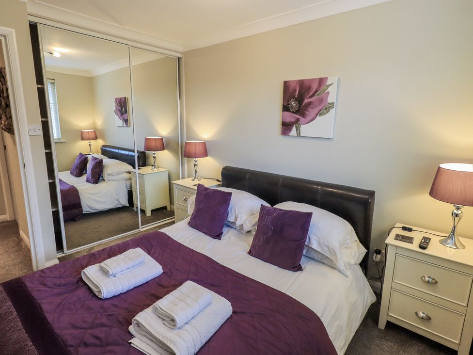 A bedroom with a bed and mirror at Lakeland Loft in Windermere