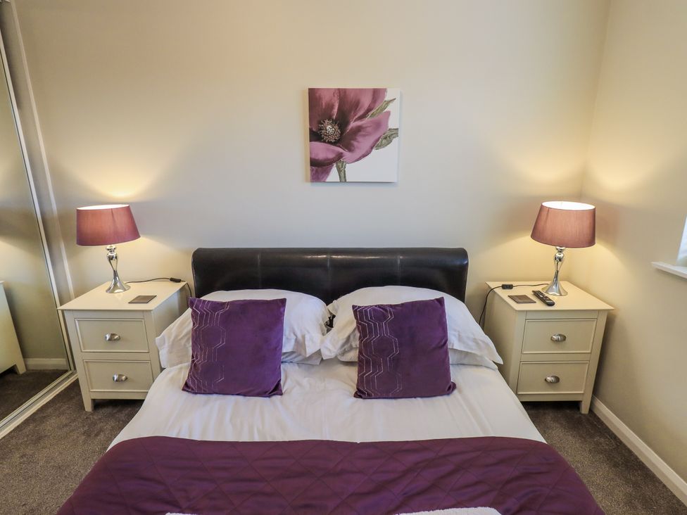 A bedroom with a bed and bedside tables at Lakeland Loft in Windermere