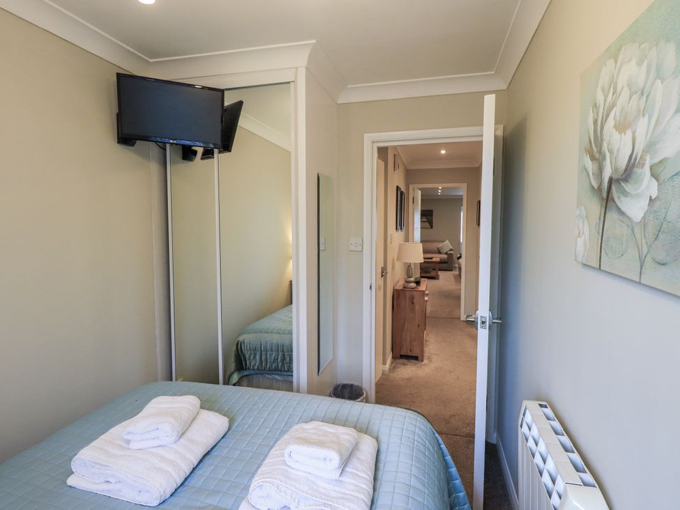 A bedroom with a bed and television at Lakeland Loft in Windermere