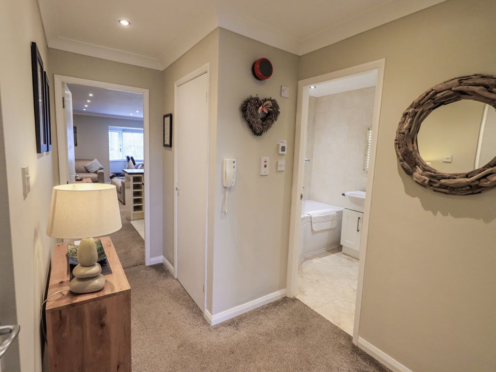 A hallway with a lamp and table at Lakeland Loft in Windermere