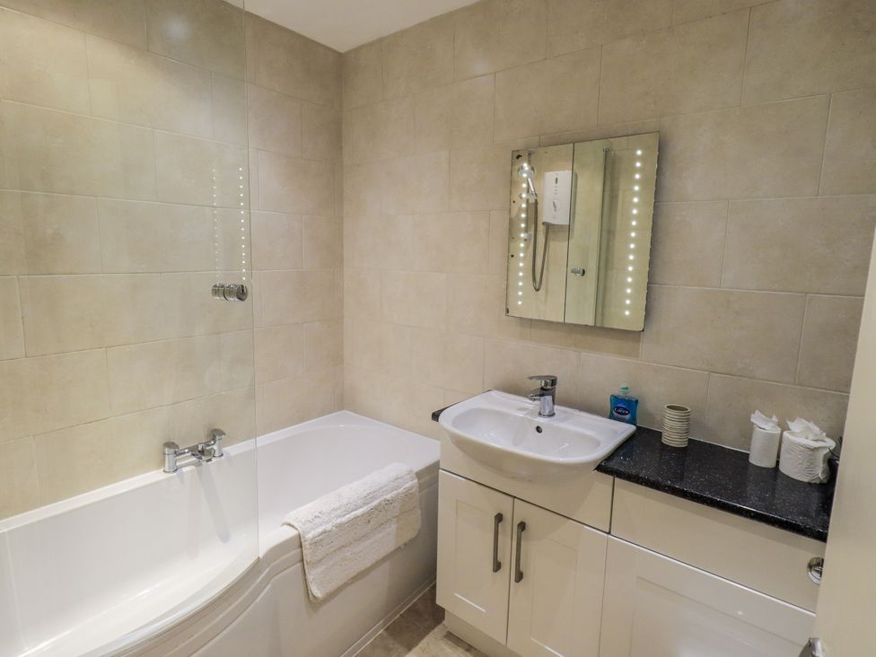 A bathroom with a bathtub and sink at Lakeland Loft in Windermere