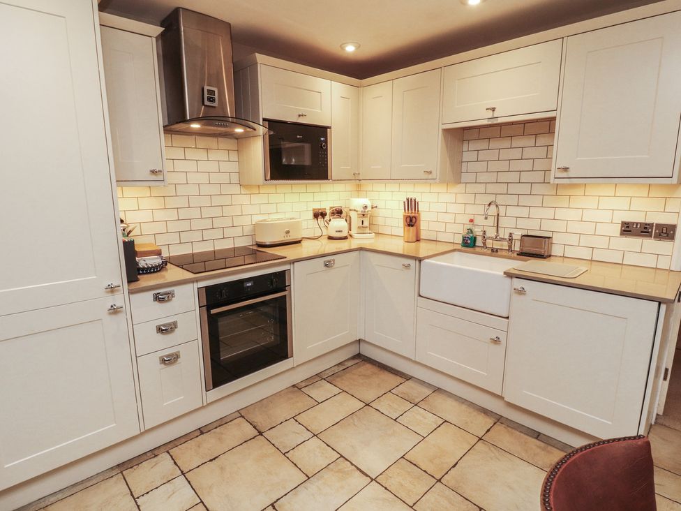 A kitchen with cabinets, appliances, and a sink at Chapel How, Ambleside