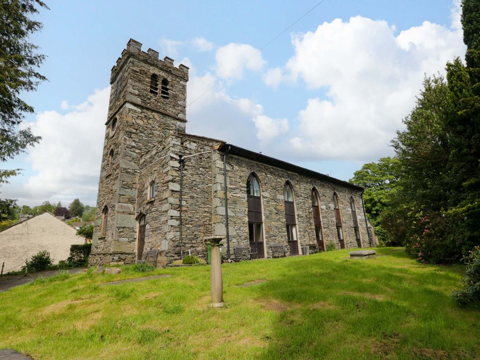 A stone church with a bell tower and arched windows at Chapel How in Ambleside