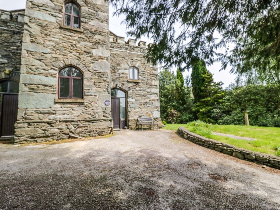 An outdoor area with stone walls and a bench at Chapel How in Ambleside