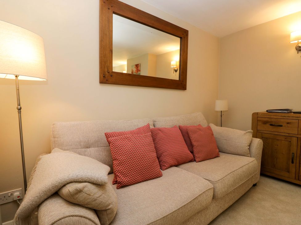 A living room with a sofa and lamp at Chapel How in Ambleside