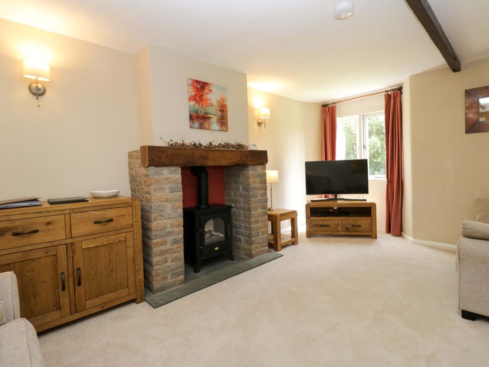 A living room with a fireplace and television at Chapel How in Ambleside