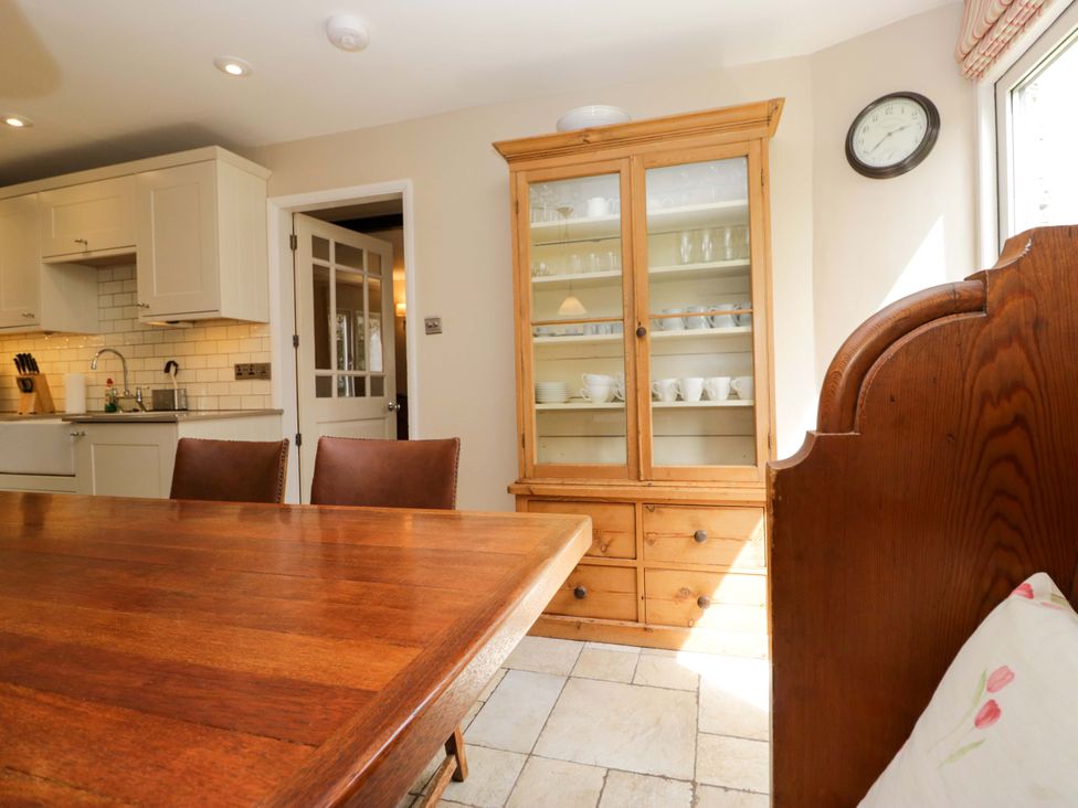 A kitchen with a wooden dining table and storage cabinet at Chapel How Ambleside