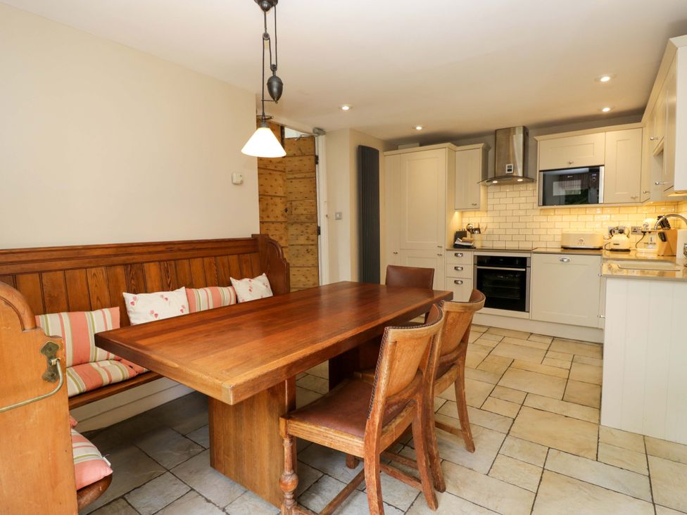 A kitchen with a dining table and bench at Chapel How in Ambleside