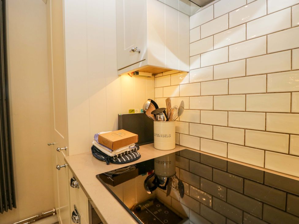 A kitchen with cabinets and utensils at Chapel How Ambleside
