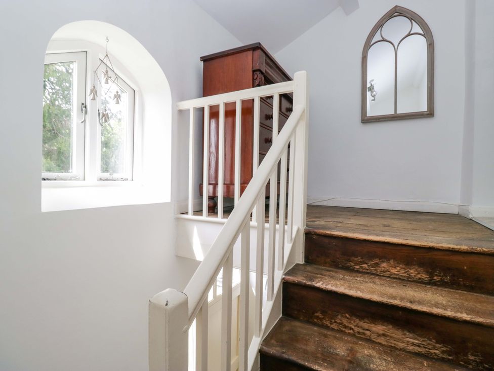 A staircase with a chest of drawers and a window at Chapel How, Ambleside