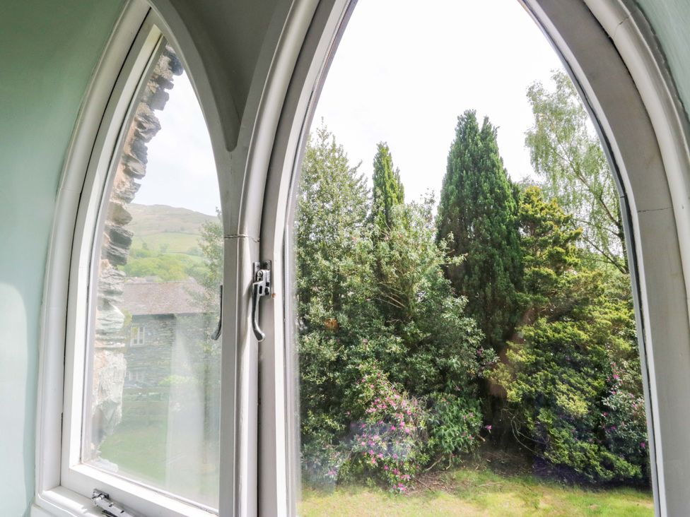 A window view showing trees and a building at Chapel How Ambleside