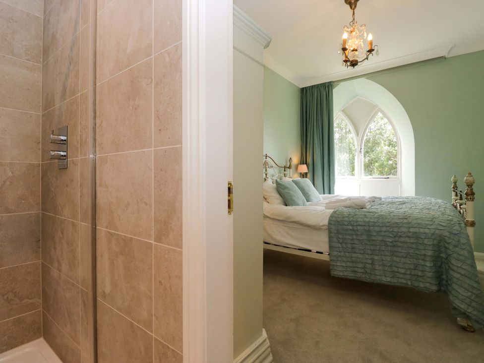 A bedroom with a bed and shower at Chapel How in Ambleside