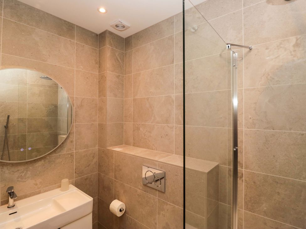 A bathroom with a sink, toilet, and shower at Chapel How in Ambleside