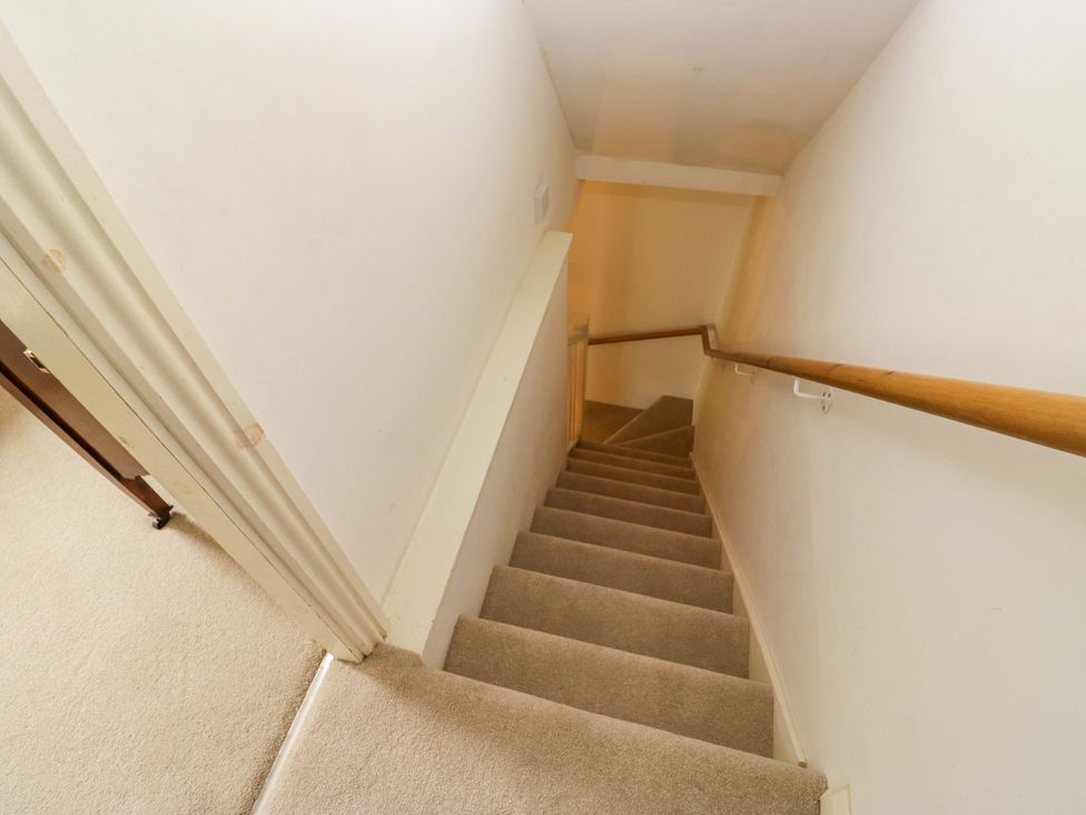 A staircase with carpet and handrail at Chapel How Ambleside