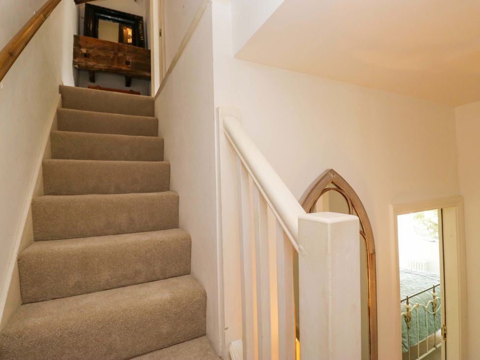 A staircase with a handrail leading upstairs at Chapel How in Ambleside