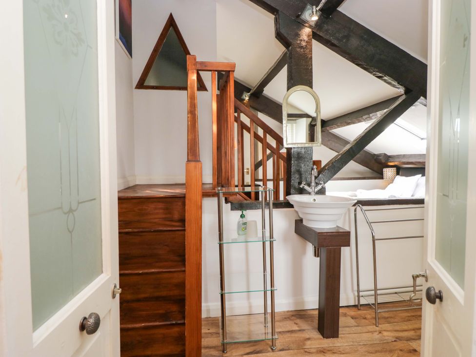 A bedroom with a sink and staircase at Chapel How Ambleside