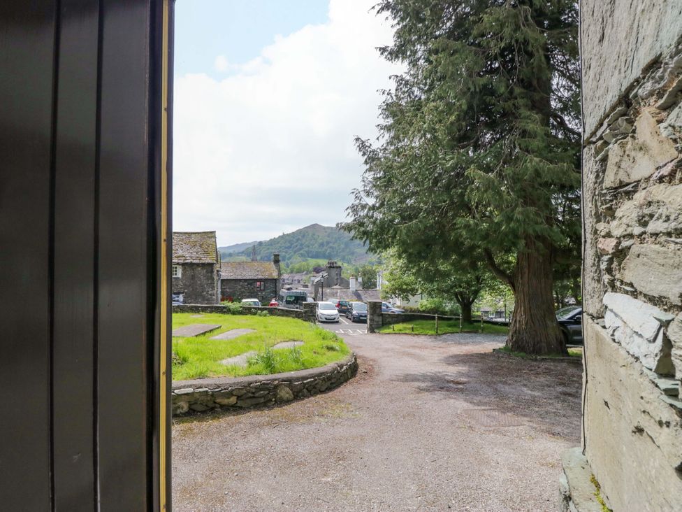 A view from a doorway showing trees and cars at Chapel How Ambleside