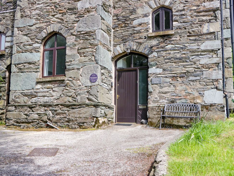 An entrance with a stone wall and a bench at Chapel How Ambleside