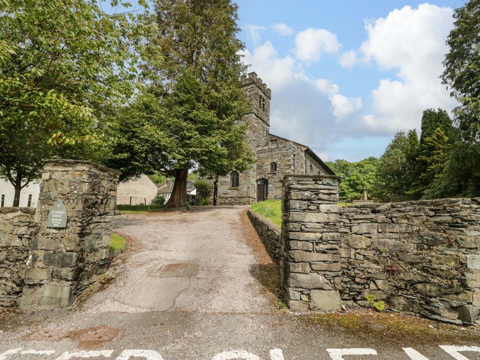 A church with stone walls and trees at Chapel How in Ambleside