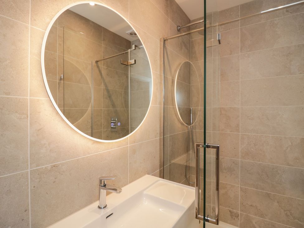 A bathroom with a mirror and shower at Chapel How in Ambleside