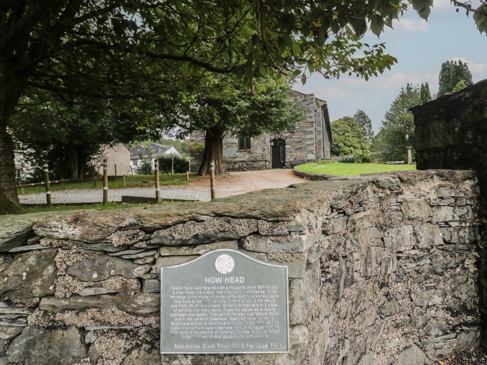 An outdoor area with a stone wall and an information plaque at Chapel How in Ambleside