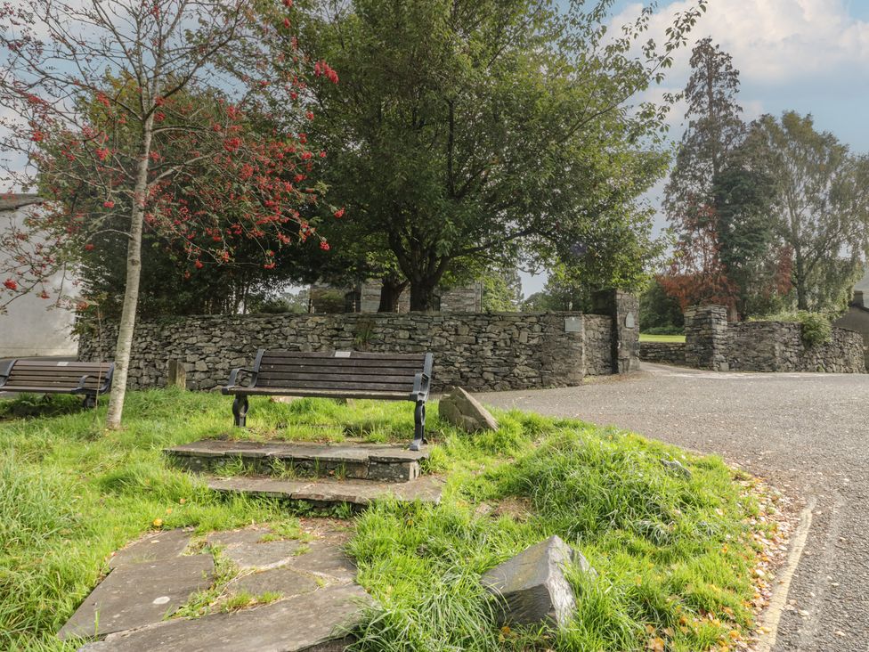 An outdoor area with benches and a stone wall at Chapel How Ambleside