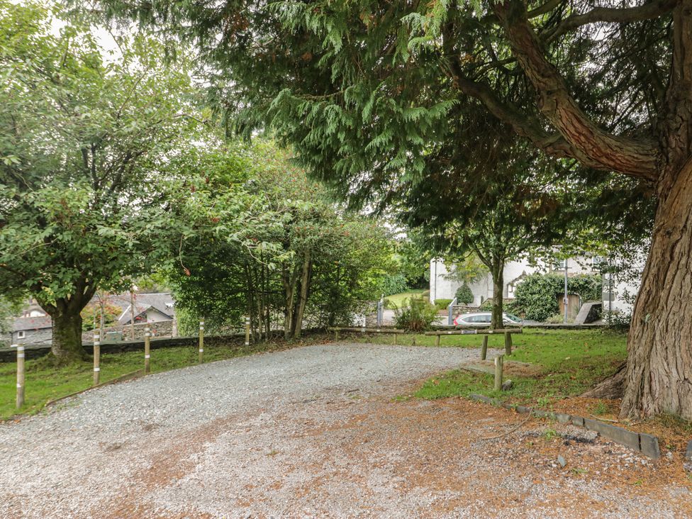 An outdoor area with a gravel driveway and trees at Chapel How in Ambleside