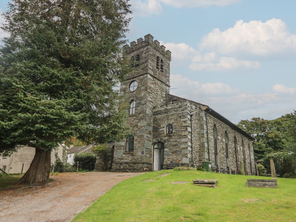 A church building surrounded by grass and trees at Chapel How in Ambleside