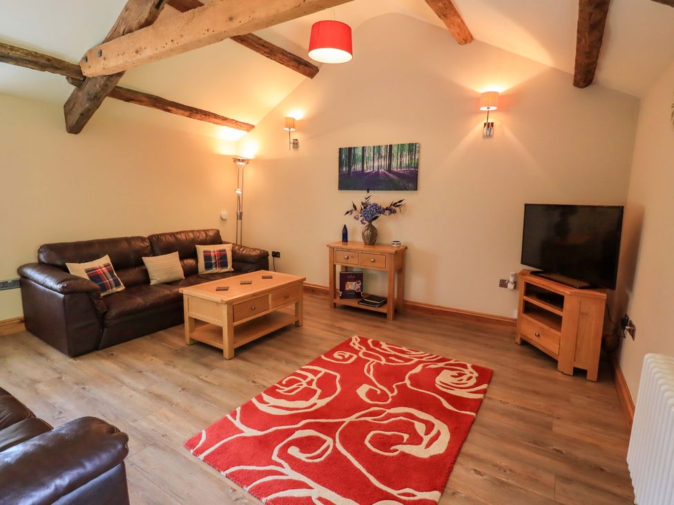 A living room with a sofa and a coffee table at Abbots Reading Mews 1 in Grizedale