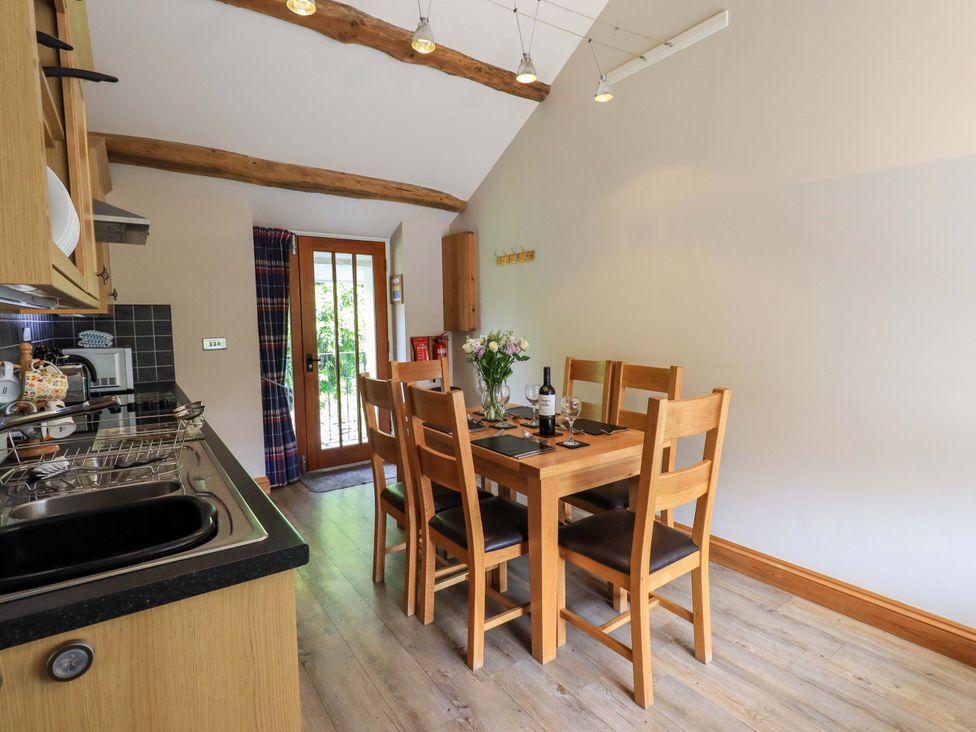A kitchen with a dining table and chairs at Abbots Reading Mews 1 in Grizedale